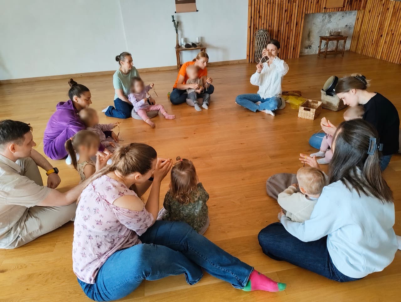 Vaikai ir tėvai sėdi ratu gyvoje Solio pamokoje